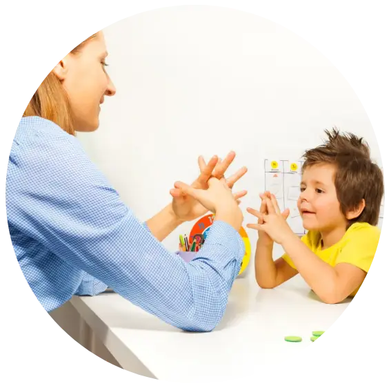 Boy exercises putting fingers with therapist